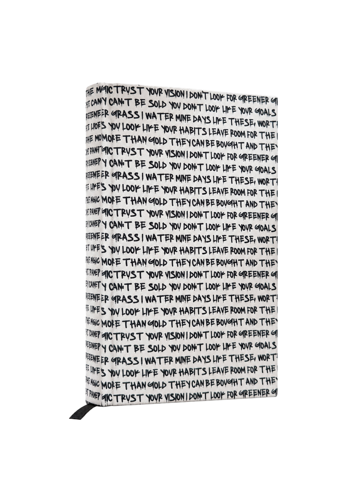 LK x Cosmic Covers Journal standing upright, with black handwritten text on a cream cover and a black ribbon bookmark.